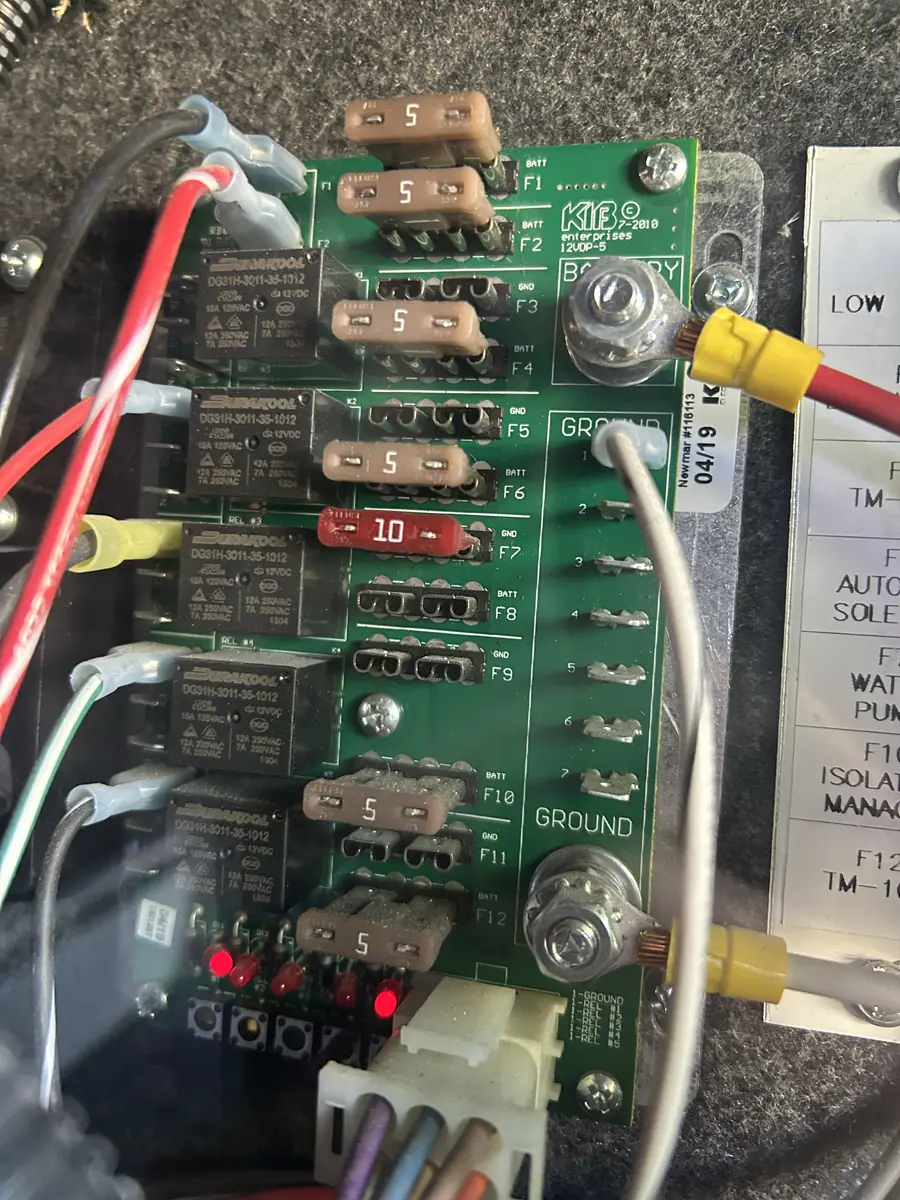 Close-up of a KIB 12VDC fuse and relay distribution board in a Newmar RV electrical bay.