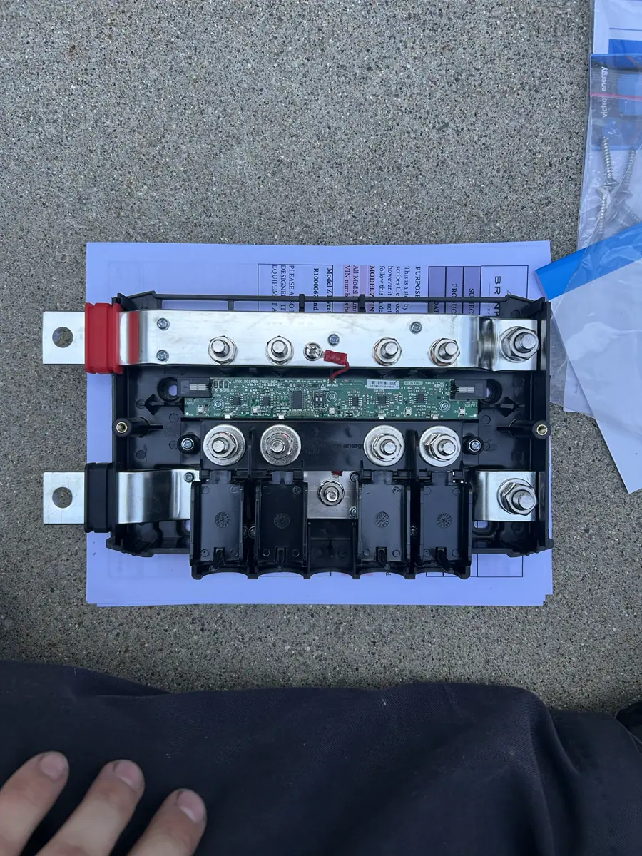 Open Victron Lynx Distributor busbar and fuse module on manuals during an RV power-system install.